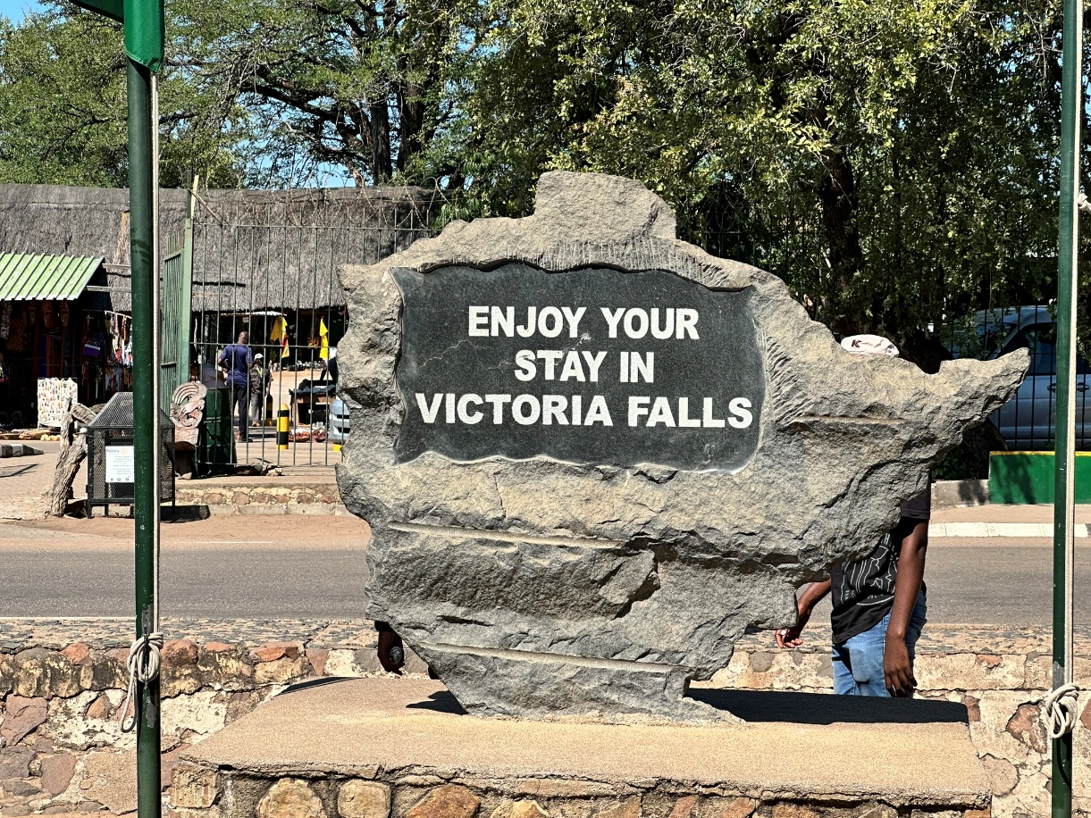 A stone sign reading "Enjoy Your Stay" at Victoria Falls