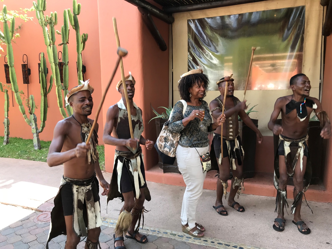 A woman poses next to a group dressed in traditional attire